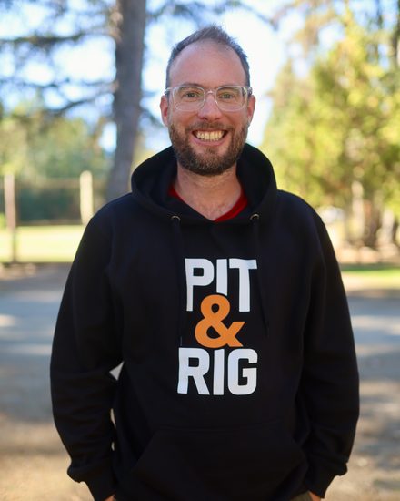 Jean-Pascal Remon, Pit & Rig's founder, smiling outdoors in a black Pit & Rig hoodie.